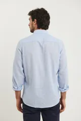 Camisa de manga larga confeccionada en una mezcla de algodón y lino, con cuello abotonado, cierre frontal de botones y un bolsillo en el pecho.