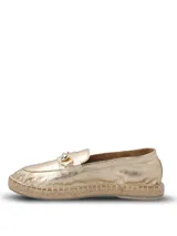 Alpargatas tipo mocasín color dorado metalizado, con detalle de herraje metálico en el empeine y suela de yute con base de goma.