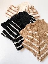 Sweater tejido con diseño a rayas horizontales. Disponible en color beige con rayas marrones, negro con rayas blancas y blanco con rayas marrones.