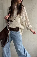 Camisa beige de rayas verticales, de calce relajado y tejido liviano, con mangas largas y cuello camisero.
