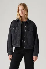 Campera de jean Levi's modelo 90s Trucker, color negro gastado, con cuello clásico, cierre frontal con botones metálicos, bolsillos con solapa en el pecho y corte holgado.