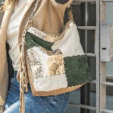 Cartera bandolera de cuero vacuno con diseño patchwork en colores verde, blanco, dorado y marrón. Tiene correa larga regulable, manija corta, dos bolsillos verticales con cierre en el frente, bolsillo con cierre en la parte posterior, forro interior de tela con bolsillo con cierre y bolsillo para celular.