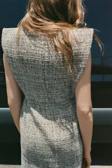 Vestido midi ZARA Woman Collection de tweed gris con sutiles hilos de colores, escote redondo, manga sisa y bajo desflecado con abertura en la espalda. Cuenta con cierre de cremallera oculta.