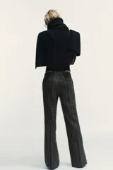 Pantalón de tiro alto con diseño de cuadros, corte recto y cintura con trabillas. Cuenta con bolsillos laterales, falsos bolsillos traseros de vivo y cierre frontal con cremallera, botón y ganchos metálicos.
