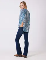 Blusa de gasa con estampado geométrico y paisley en tonos fucsia y blanco. Presenta cuello mao con escote en V, mangas tres cuartos con presilla y botón para regular el largo.