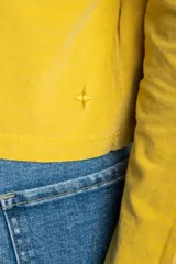 Remera oversize de manga larga color marrón, con cuello redondo y efecto de lavado. Presenta un pequeño bordado en forma de estrella en la parte inferior.