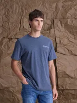 Remera de algodón color azul jaspeado, con cuello redondo, manga corta y estampado pequeño en el pecho.