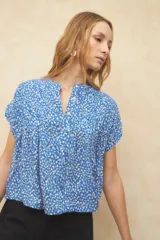 Blusa verde con estampado de hojas color salmón, cuello mao y mangas cortas.