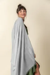 Chal de tejido ligero con acabado brillante en tono plateado y terminación de flecos en los extremos.