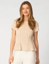 Remera blanca de manga corta con cuello redondo, confeccionada en una mezcla de modal, poliéster y elastano. Presenta un diseño con alforzas verticales en el frente que aportan estructura y una silueta relajada.