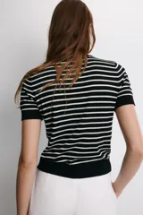 Jersey de punto de manga corta con cuello redondo, a rayas horizontales blancas y negras.