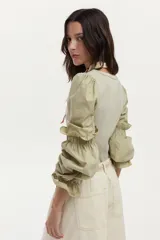 Blusa de rib y popelina color blanco, con calce al cuerpo, escote cuadrado y mangas voluminosas con volados.