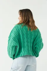 Sweater verde esmeralda de punto con diseño trenzado y textura en relieve, fit amplio y cómodo, con hombros caídos y cuello redondo.