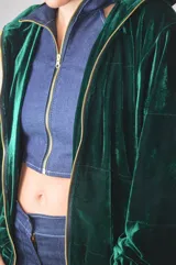 Campera verde inglés de terciopelo con cierre dorado, mangas abullonadas y puños elastizados.