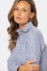 Camisa de manga larga con rayas verticales grises y blancas, corte holgado y bolsillo en el pecho.