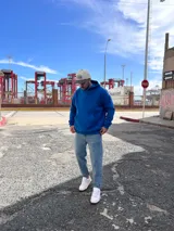 Canguro azul francia con capucha, confeccionado en algodón. Presenta un diseño gráfico estampado en la espalda con el texto 'EXTRA CHANCE' y frases motivacionales en color blanco.