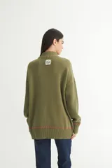 Buzo color verde oliva de punto con cuello alto, mangas largas y calce oversize.