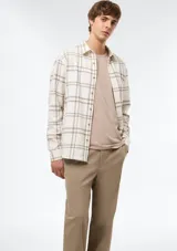 Camisa de franela a cuadros color beige y blanco, de manga larga y cierre frontal con botones.