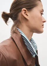 Camisa de popelín de algodón orgánico con diseño oversize, cuello camisero, manga larga con puños abotonados y cierre frontal de botones.