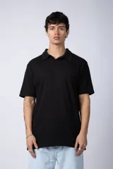 Chomba de algodón color negro, de corte clásico y manga corta, con cuello polo y cierre frontal de botones.