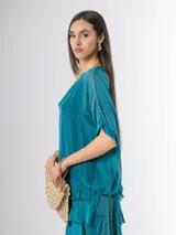 Vestido midi de seda italiana color negro, diseño dos en uno con capa superior de calce amplio, falda con volados y forro interior de algodón elastizado.