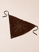 Bandana de cuero gamuza color marrón chocolate, decorada artesanalmente con tachas metálicas dispuestas en un diseño en forma de sol. Cuenta con tiras laterales para atar.