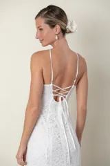 Vestido largo de encaje blanco, con breteles finos cruzados en la espalda y escote halter con abertura en forma de gota.