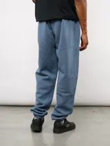 Pantalón de jogging de felpa con friza, color gris, con cintura elástica, bolsillos laterales y puños en los tobillos. Presenta un parche con el logo de Umbro en la parte superior delantera.