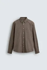 Camisa relaxed fit de algodón con estampado de cuadros en tonos marrón y beige. Cuenta con cuello solapa, manga larga con puño abotonado, bolsillo plastrón en el pecho y cierre frontal de botonadura.