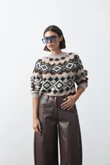 Pantalón de cuero sintético con fit barrel, de silueta amplia con volumen en las piernas y botamanga levemente entallada. Presenta bolsillos laterales y cierre frontal.