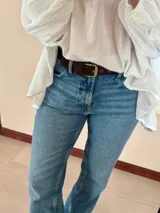 Cinturón de jean con hebilla dorada.