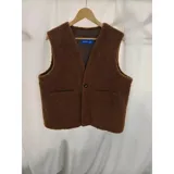 Chaleco de corderito color marrón, de diseño reversible, sin cuello, con cierre de un botón frontal y bolsillos aplicados.