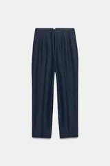 Pantalón de tiro alto y corte slim fit, color azul marino con diseño de rayas diplomáticas. Es de largo tobillero, cuenta con bolsillos delanteros de vivo y costuras marcadas en el delantero y la espalda. Cierre frontal con cremallera, botón interior y gancho metálico.