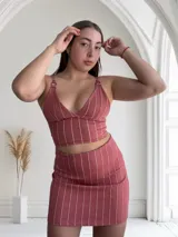 Top rosado con rayas verticales blancas, breteles finos regulables con aros metálicos y escote en V.