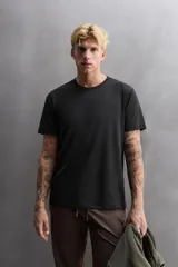 Camiseta de entrenamiento de ajuste regular, color verde oliva, confeccionada en tejido técnico ligero y elástico con estructura. Presenta cuello redondo, manga corta y costuras planas.