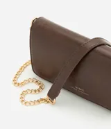 Cartera bandolera Satinato de poliuretano color marrón, con diseño rectangular, solapa frontal y asa de cadena metálica dorada.