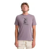 Remera lila de manga corta con estampado gráfico frontal en tonos oscuros que incluye una pila de rocas y texto.
