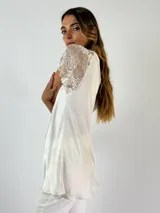 Blusa blanca de viscosa con escote en V y mangas cortas de encaje floral.