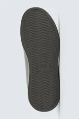 Zapatillas urbanas de cuero sintético negro, con cordones y suela gruesa monocolor.