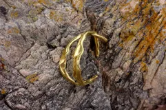 Brazalete rígido de bronce y alpaca maciza, con diseño orgánico irregular.