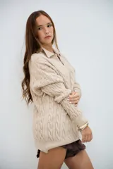 Sweater de punto trenzado color beige, con cuello en V y cuello polo, de manga larga y corte holgado.