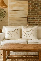 Almohadón cuadrado de lino color crema con bordado de hilo natural con diseño de caballo. Incluye relleno de alta densidad y suavidad, y cierre invisible para fácil lavado.