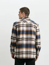 Sobrecamisa de manga larga con diseño a cuadros, cuello camisero y bolsillo frontal. Confeccionada en tejido de poliéster y algodón, sin forro.