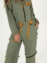 Mono largo color verde con detalles en marrón y amarillo. Tiene cierre frontal, cuello camisero, mangas largas, bolsillos grandes con solapa y puños con cierre.