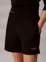 Shorts de felpa francesa color negro, con talle alto, cintura elástica y bolsillos laterales. Presenta el logo de la marca bordado en el bajo.
