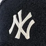 Gorra de visera curva New Era modelo 9Forty, confeccionada en tejido tipo borreguito (sherpa) color azul marino. Presenta el logo de los New York Yankees bordado en blanco en el frente y el logo de la marca en el lateral.