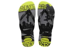 Sandalias tipo ojotas Havaianas con diseño gráfico de skate park en tonos gris, negro y amarillo neón. Presentan tiras negras con el logo de la marca y una base con estampado urbano.