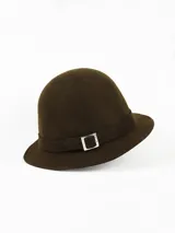 Sombrero de dama estilo cloche confeccionado en paño de lana impermeable, color marrón, con cinta decorativa y hebilla metálica plateada.