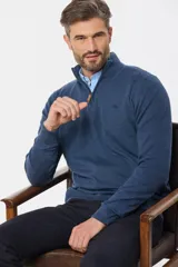 Buzo de tejido fino en hilo de algodón, color rosado, con cuello alto y cierre frontal parcial con detalle en cuero. Presenta puños y ruedo acanalados y un pequeño logo bordado en el pecho.