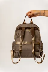 Mochila negra de tela impermeable con detalles en cuero marrón.